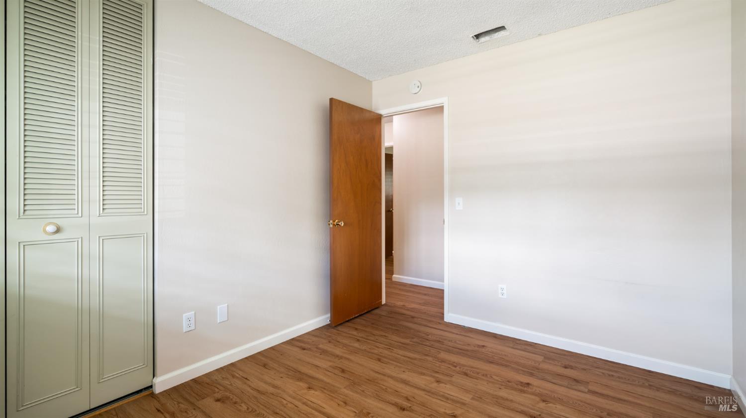 1536 Sunview Court Santa Rosa, CA 95401 - Photo 15 of 28 a view of an empty room with wooden floor and closet