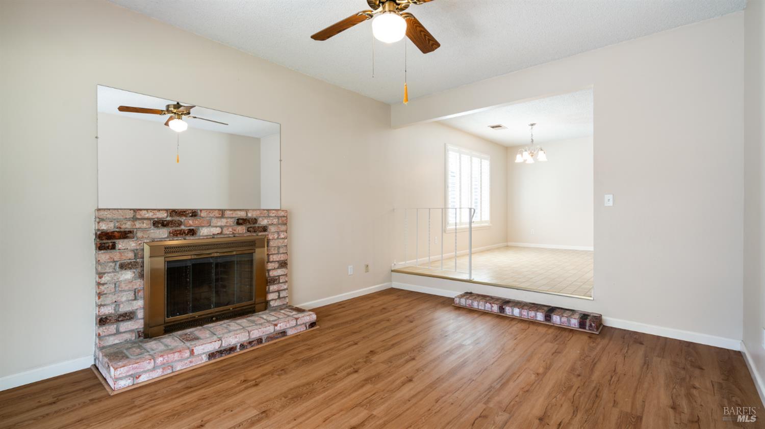 1536 Sunview Court Santa Rosa, CA 95401 - Photo 8 of 28 an empty room with wooden floor fireplace and windows
