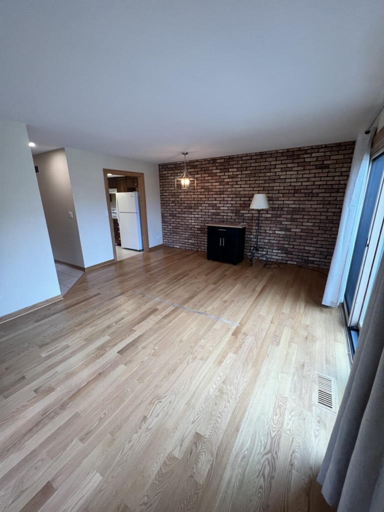 1988 Green Bay Road, Unit 1 Highland Park, IL 60035 - Photo 5 of 13 a view of an empty room with wooden floor and a window