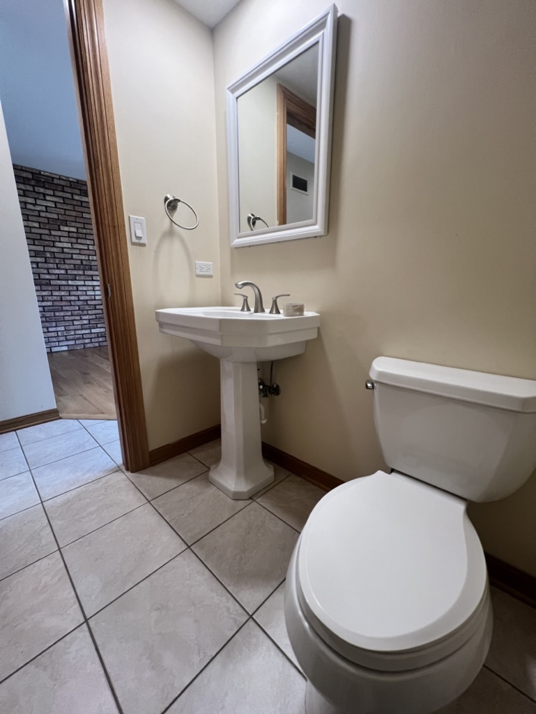 1988 Green Bay Road, Unit 1 Highland Park, IL 60035 - Photo 6 of 13 a bathroom with a toilet sink and mirror