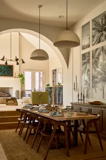 a dining room with wooden floor a chandelier a wooden table and chairs