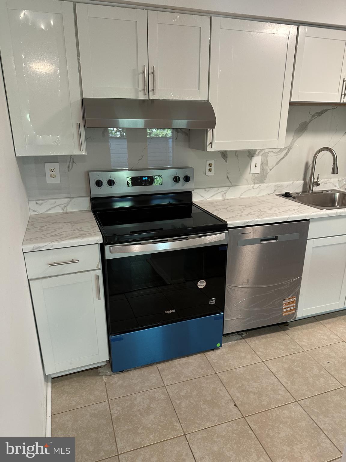 19525 Gunners Branch Road, Unit G Germantown, MD 20876 - Photo 11 of 21 a kitchen with stainless steel appliances granite countertop a stove a sink and a microwave