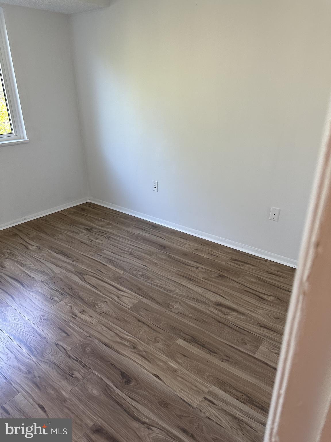 19525 Gunners Branch Road, Unit G Germantown, MD 20876 - Photo 14 of 21 a view of an empty room with wooden floor and a window