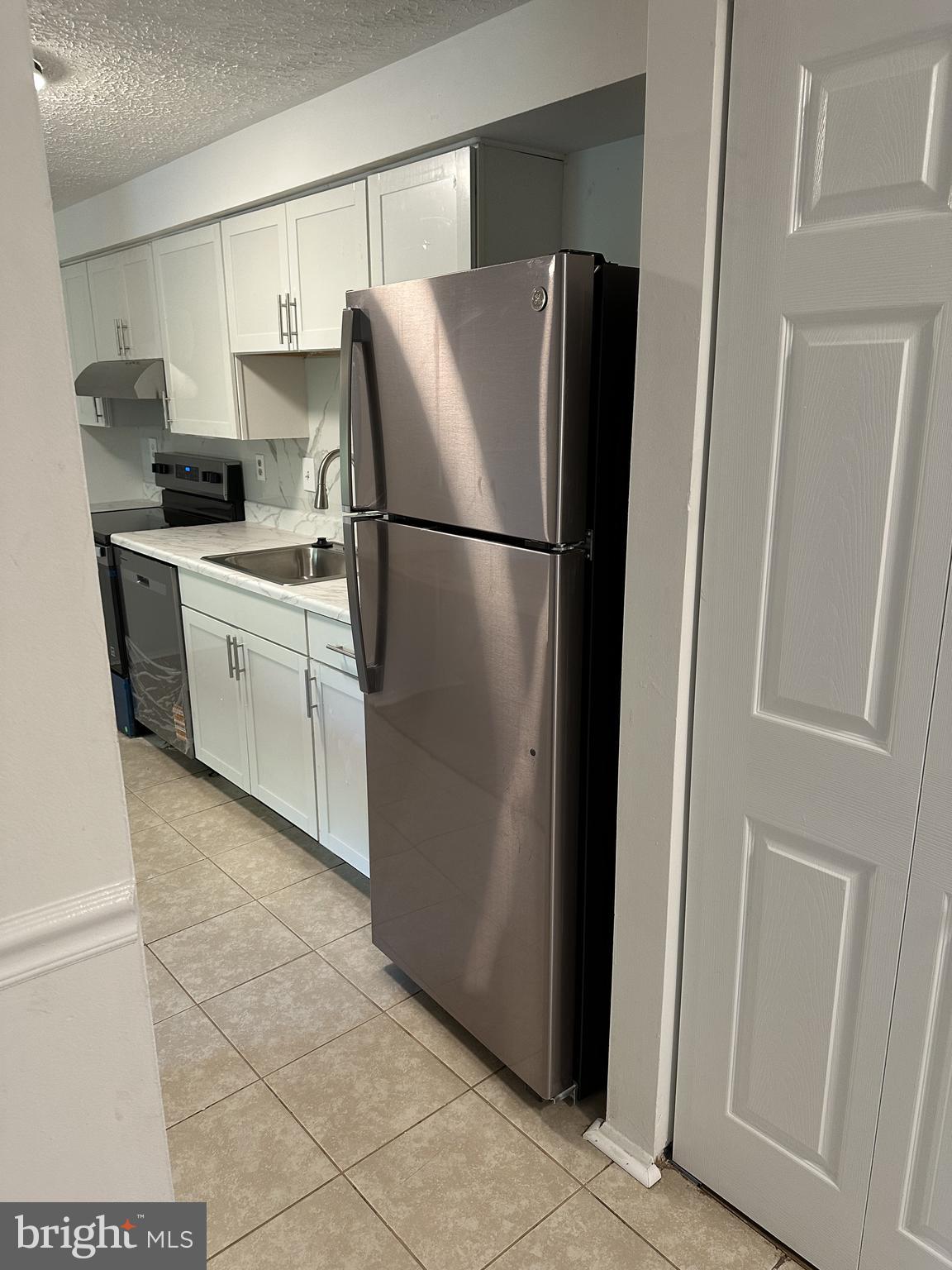 19525 Gunners Branch Road, Unit G Germantown, MD 20876 - Photo 4 of 21 a kitchen with a refrigerator sink and cabinets