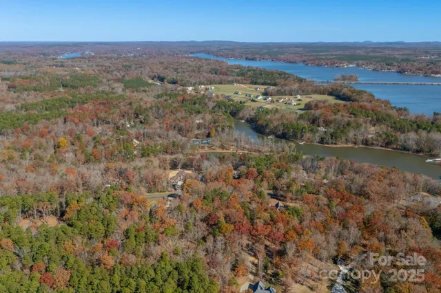 an aerial view of residential houses with outdoor space and trees