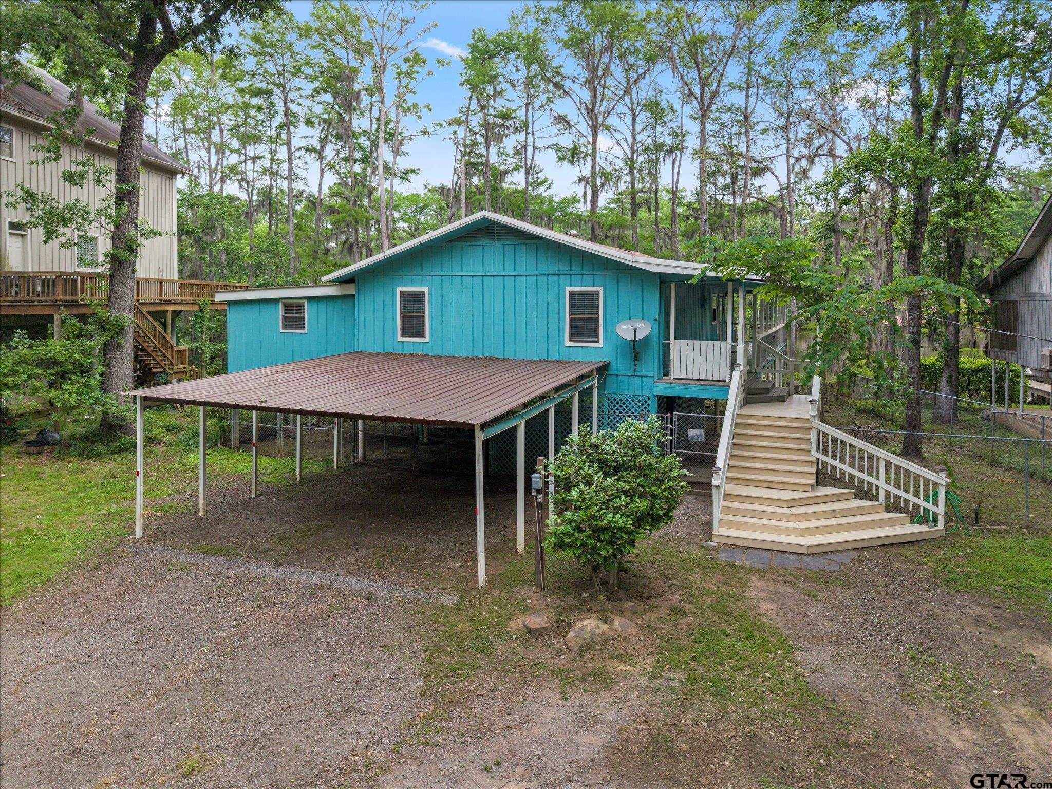230 Sesame Street West Karnack, TX 75661 - Photo 11 of 44 a backyard of a house with wooden fence and trees