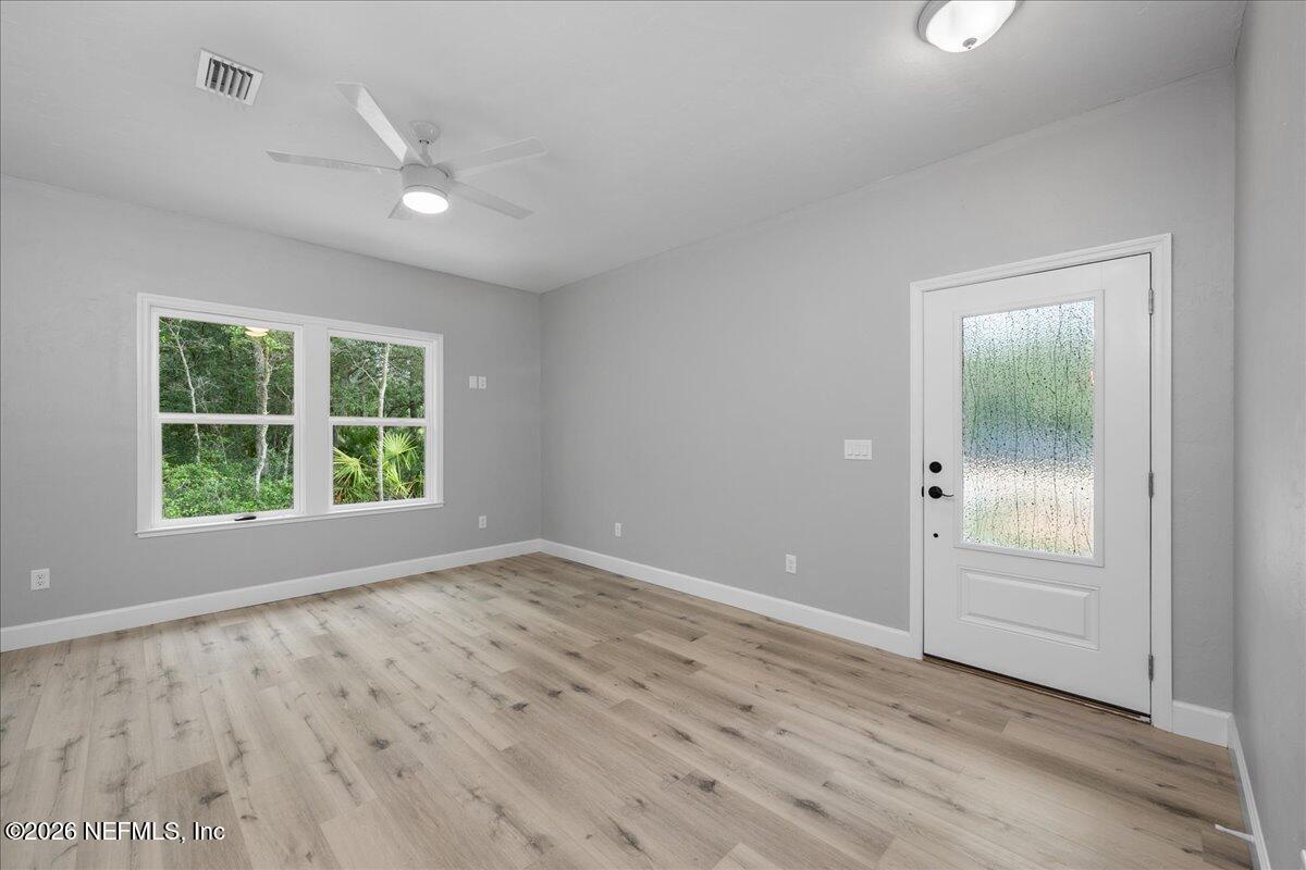 108 Pamela Street Interlachen, FL 32148 - Photo 9 of 31 wooden floor in an empty room with a window
