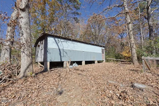 a view of a house with a small yard and wooden fence