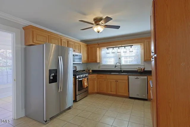 a kitchen with granite countertop stainless steel appliances a refrigerator cabinets and a window