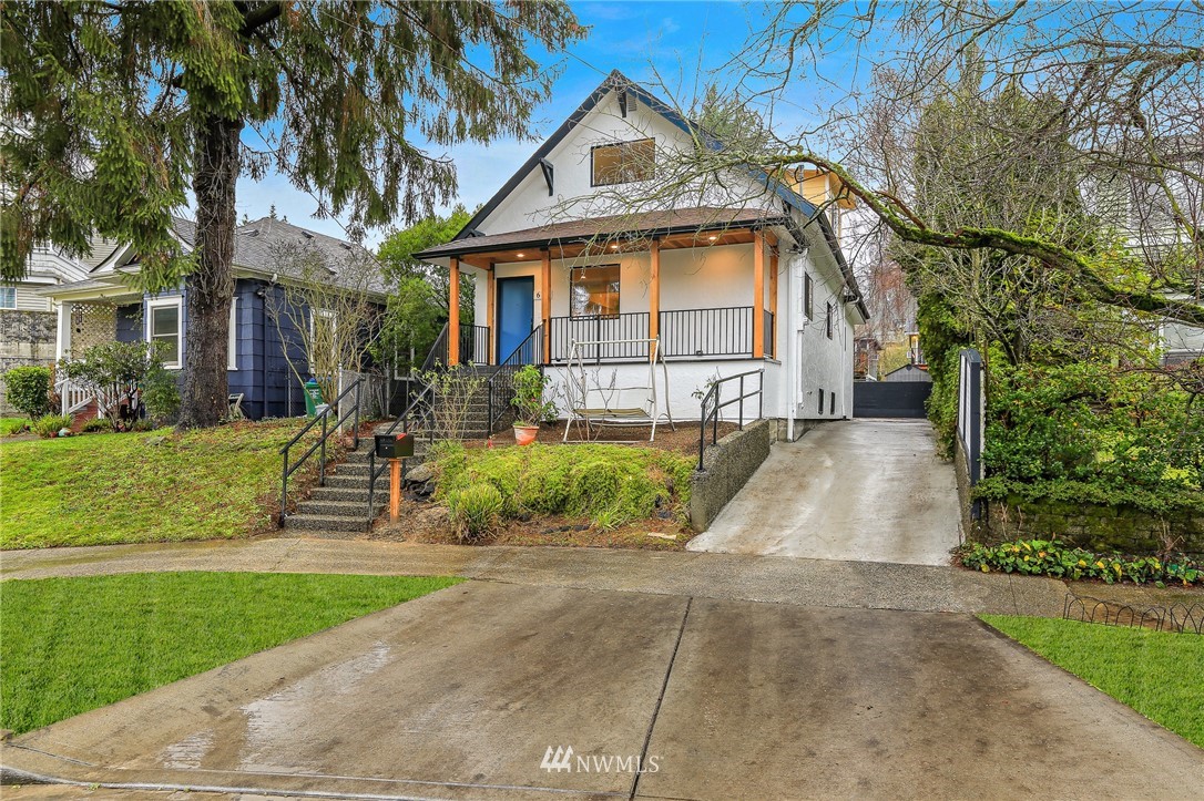 a front view of a house with a yard and potted plants