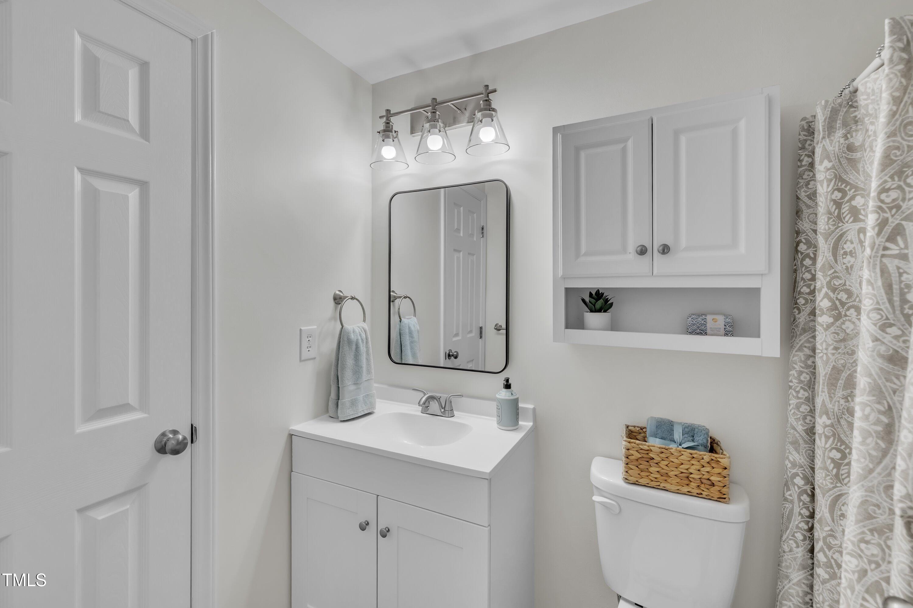 632 Middleton Avenue Cary, NC 27513 - Photo 24 of 34 a bathroom with a sink a toilet and a mirror