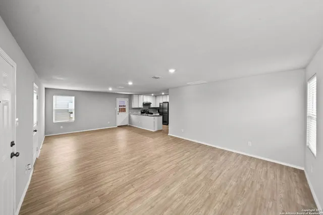 a view of empty room with wooden floor