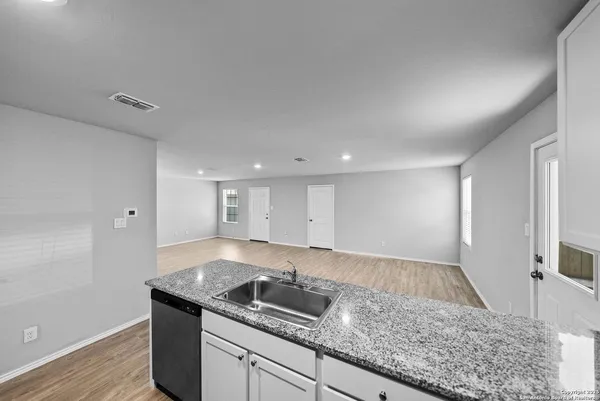 a kitchen with granite countertop kitchen island a sink a stove and a window