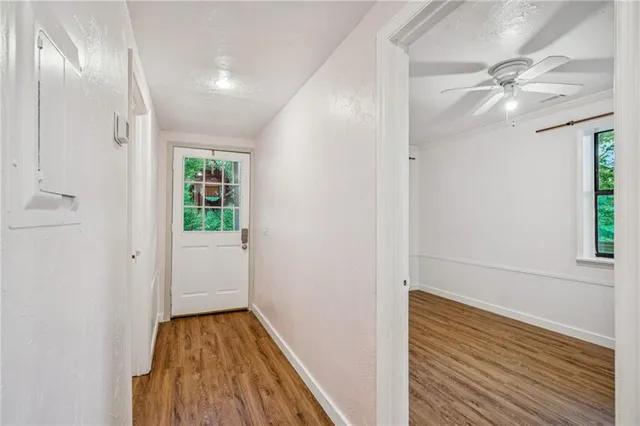 a view of an empty room with wooden floor and a window