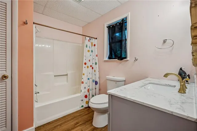 a bathroom with a sink a mirror and wooden floor