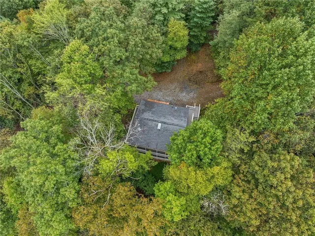 an aerial view of a house with a yard and tree s