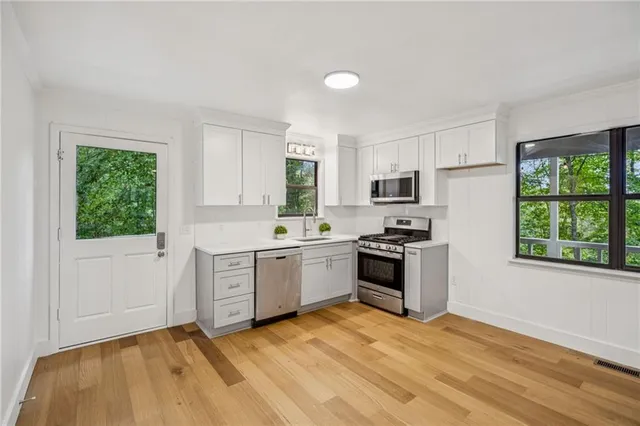 a kitchen with a sink a window and cabinets