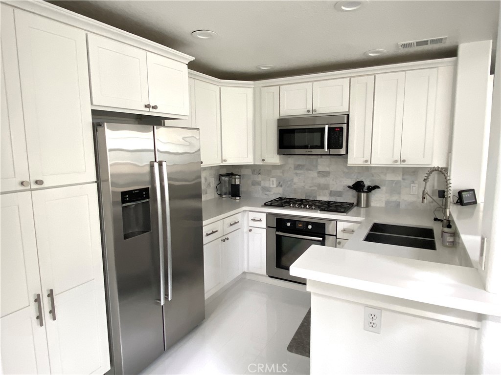 40 Anjou Newport Coast, CA 92657 - Photo 5 of 33 a kitchen with a refrigerator sink and cabinets