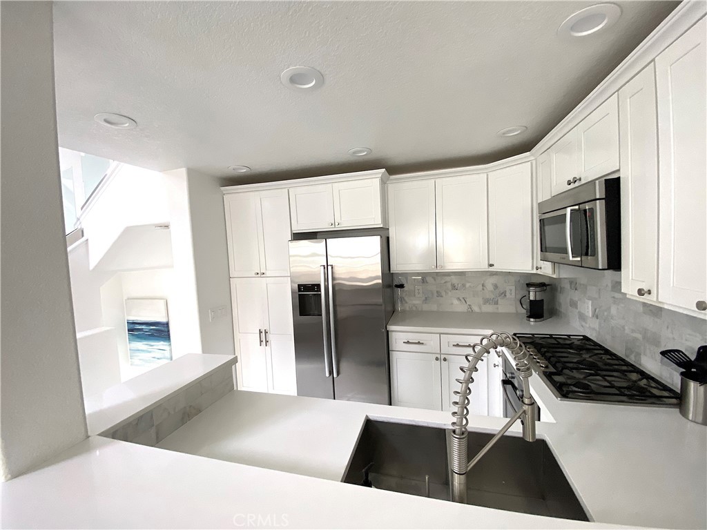 40 Anjou Newport Coast, CA 92657 - Photo 6 of 33 a kitchen with stainless steel appliances a stove a refrigerator and a sink