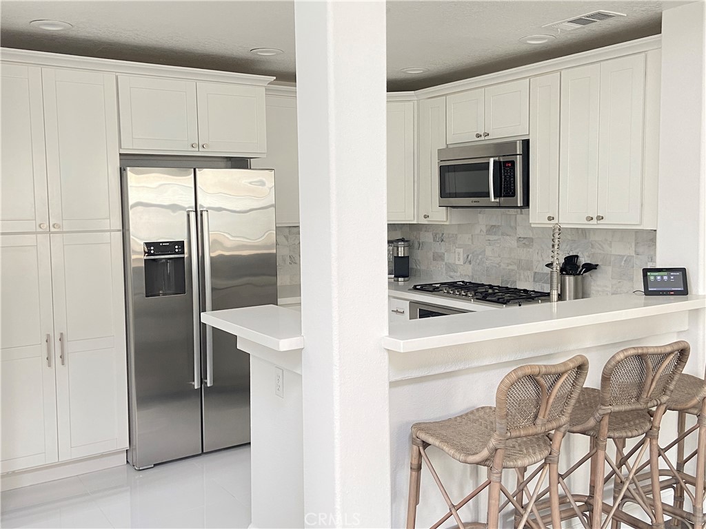 40 Anjou Newport Coast, CA 92657 - Photo 7 of 33 a kitchen with stainless steel appliances granite countertop a refrigerator and a stove top oven