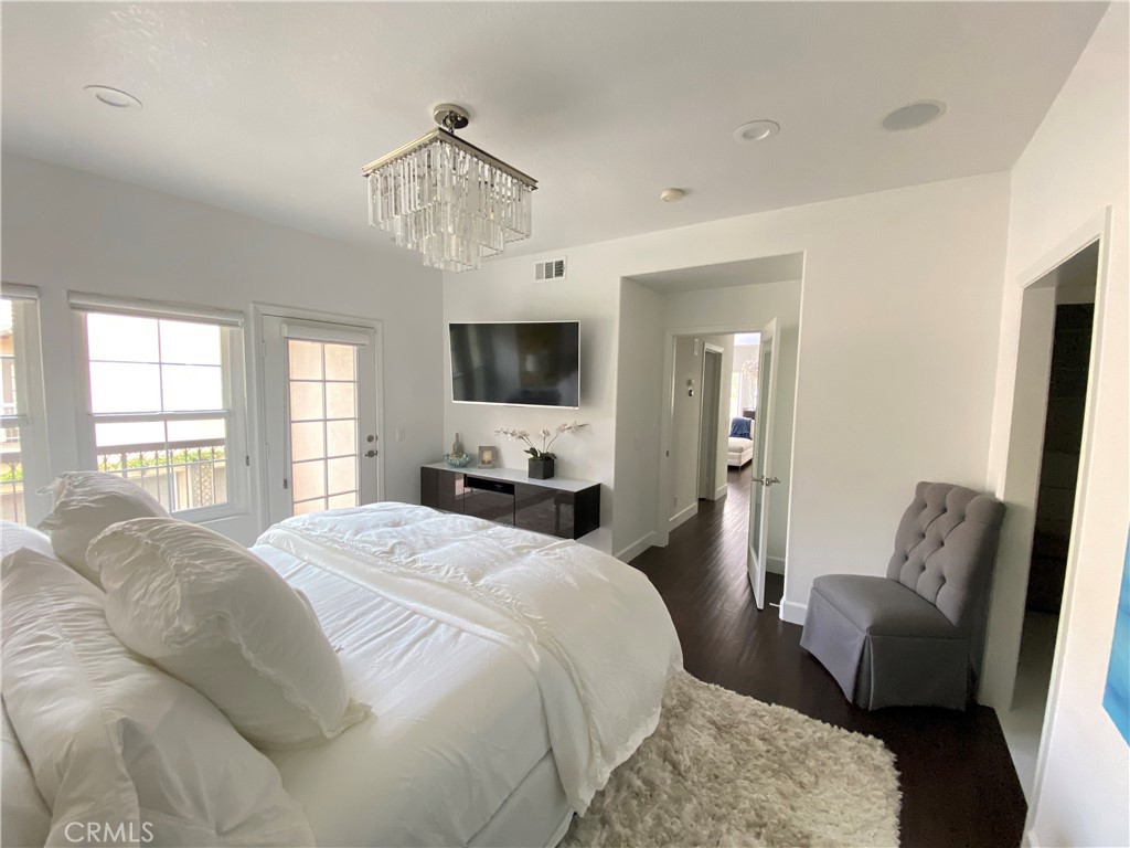 40 Anjou Newport Coast, CA 92657 - Photo 8 of 33 a bedroom with a bed a couch and a flat tv screen on the dresser