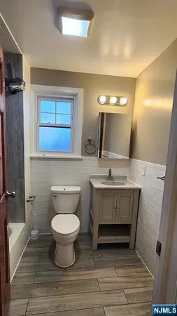 a bathroom with a sink toilet a mirror and vanity