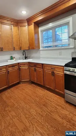 a kitchen with stainless steel appliances granite countertop a sink cabinets and wooden floor