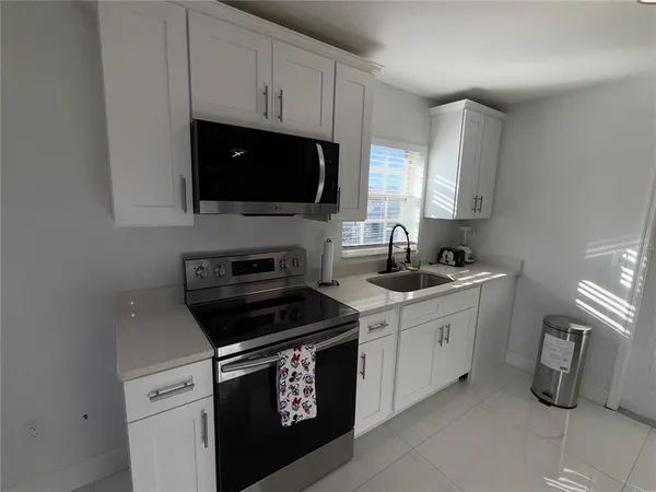 a kitchen with a sink stove and microwave