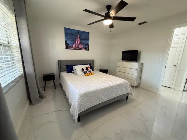 a bedroom with a bed and a flat screen tv
