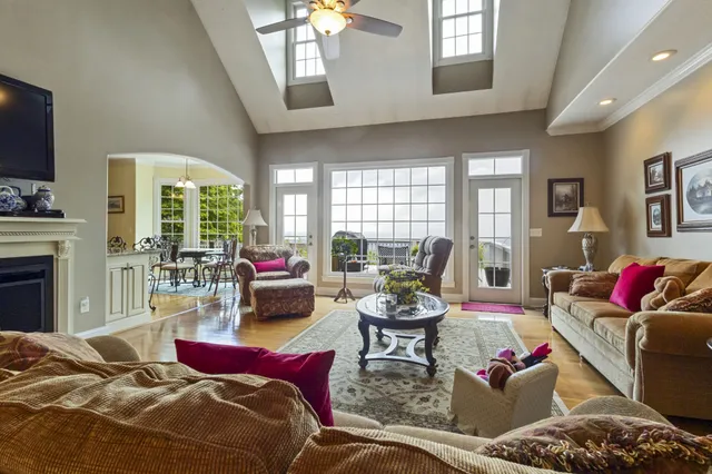 a kitchen with stainless steel appliances granite countertop a refrigerator a oven a sink a stove and a dining table with wooden floor