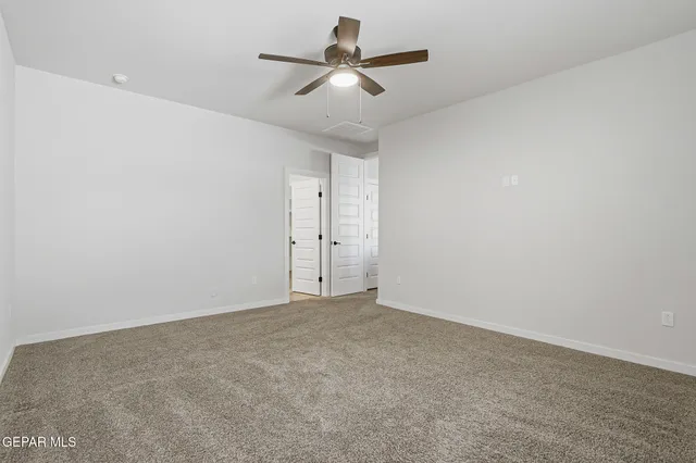 an empty room with a window and a ceiling fan