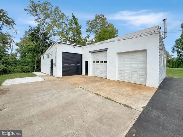 a view of a white house with a yard and garage