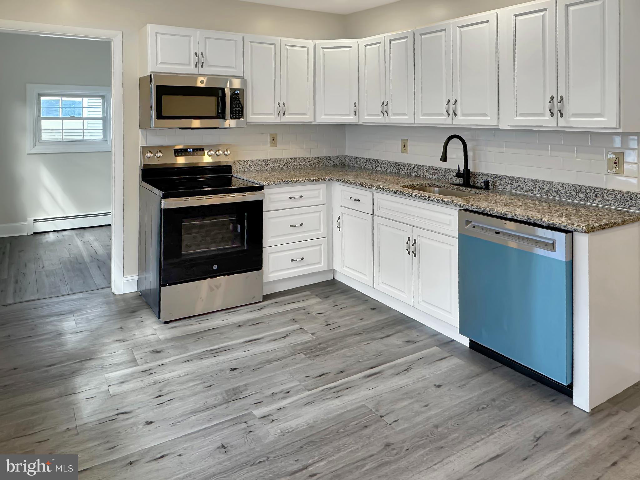 1027 Riverside Drive Pottstown, PA 19465 - Photo 5 of 24 a kitchen with stainless steel appliances granite countertop a stove a sink and white cabinets
