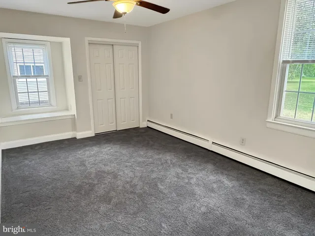 an empty room with a window and closet