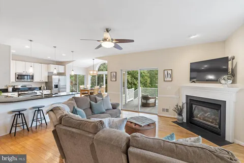 a dining room with stainless steel appliances granite countertop a kitchen island hardwood floor and a sink