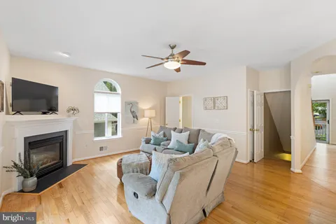 a living room with a bed furniture flat screen tv and a large window