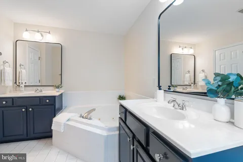 a bathroom with a granite countertop sink and a large mirror