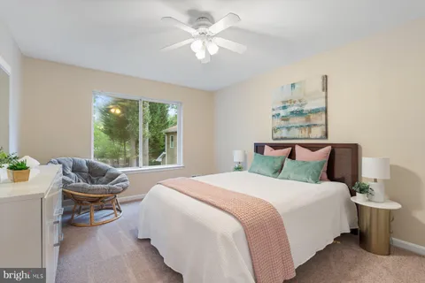 a spacious bedroom with a bed a couch and a chandelier