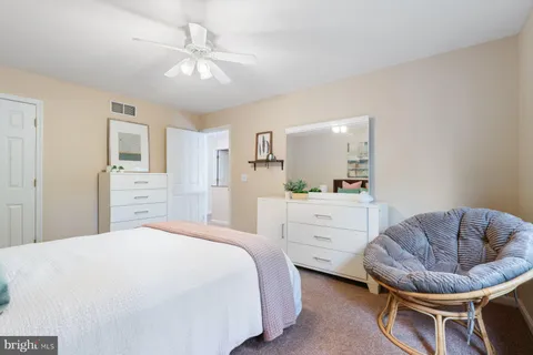 a spacious bathroom with a granite countertop sink a toilet and a mirror