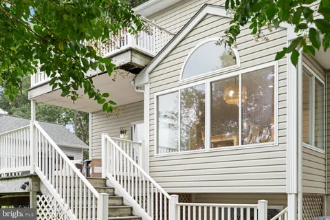 a front view of a house with a chairs and a potted plant