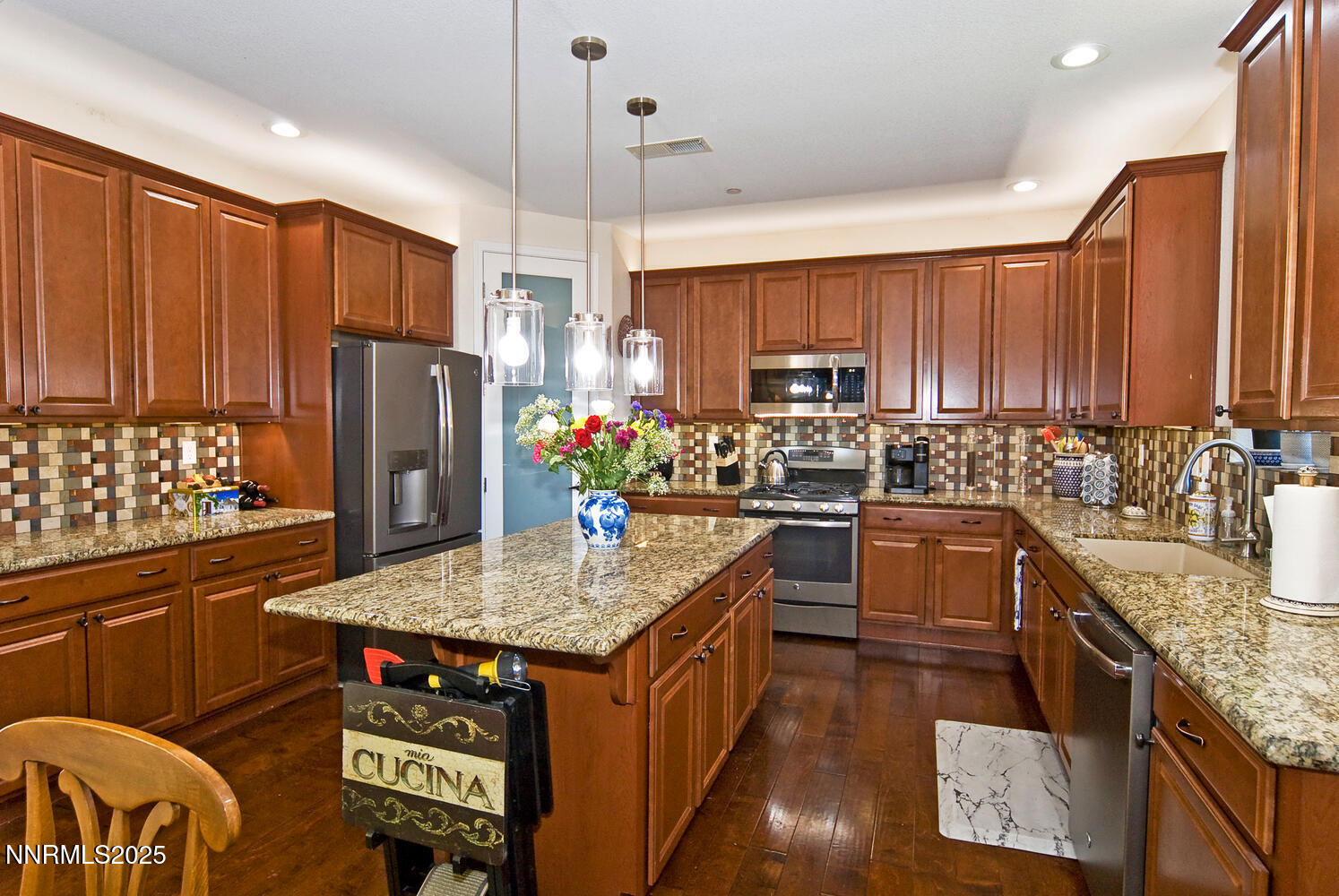 4823 Tree Swallow Lane Sparks, NV 89436 - Photo 3 of 12 a kitchen with stainless steel appliances granite countertop a refrigerator a sink dishwasher a stove a dining table and chairs with wooden floor