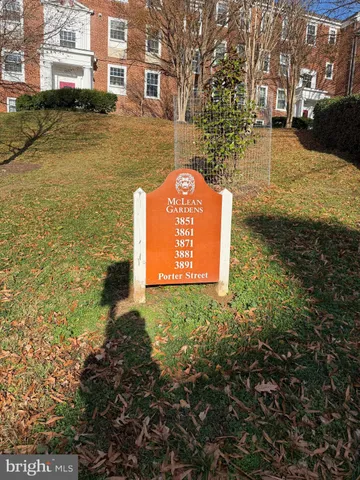 a view of a street with houses next to a yard