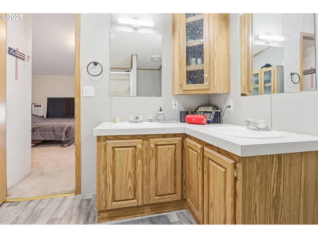 a bathroom with a sink vanity granite tub shower and a mirror