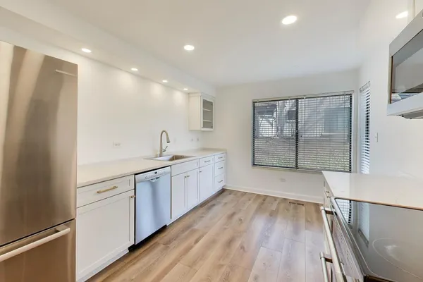 a large kitchen with a lot of counter space and wooden floor