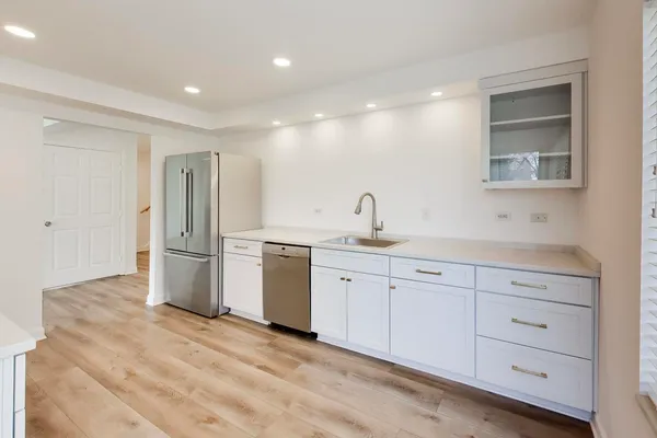 a kitchen with white cabinets and stainless steel appliances