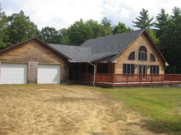 a view of a house with a yard and large tree