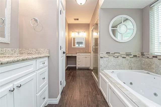 a spacious bathroom with a granite countertop tub and a mirror