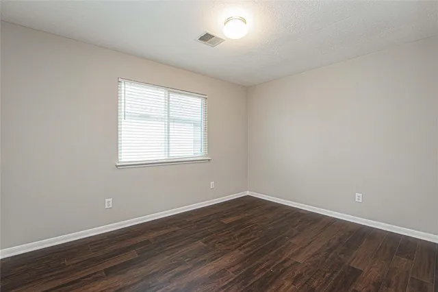 a view of a room with wooden floor and windows in it