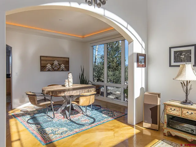 a living room with furniture a table and a large window