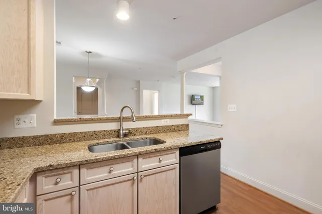 a kitchen with granite countertop a sink and cabinets